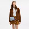 Mini Carey-crossbodytas in ‘Loved Denim’ met bedels