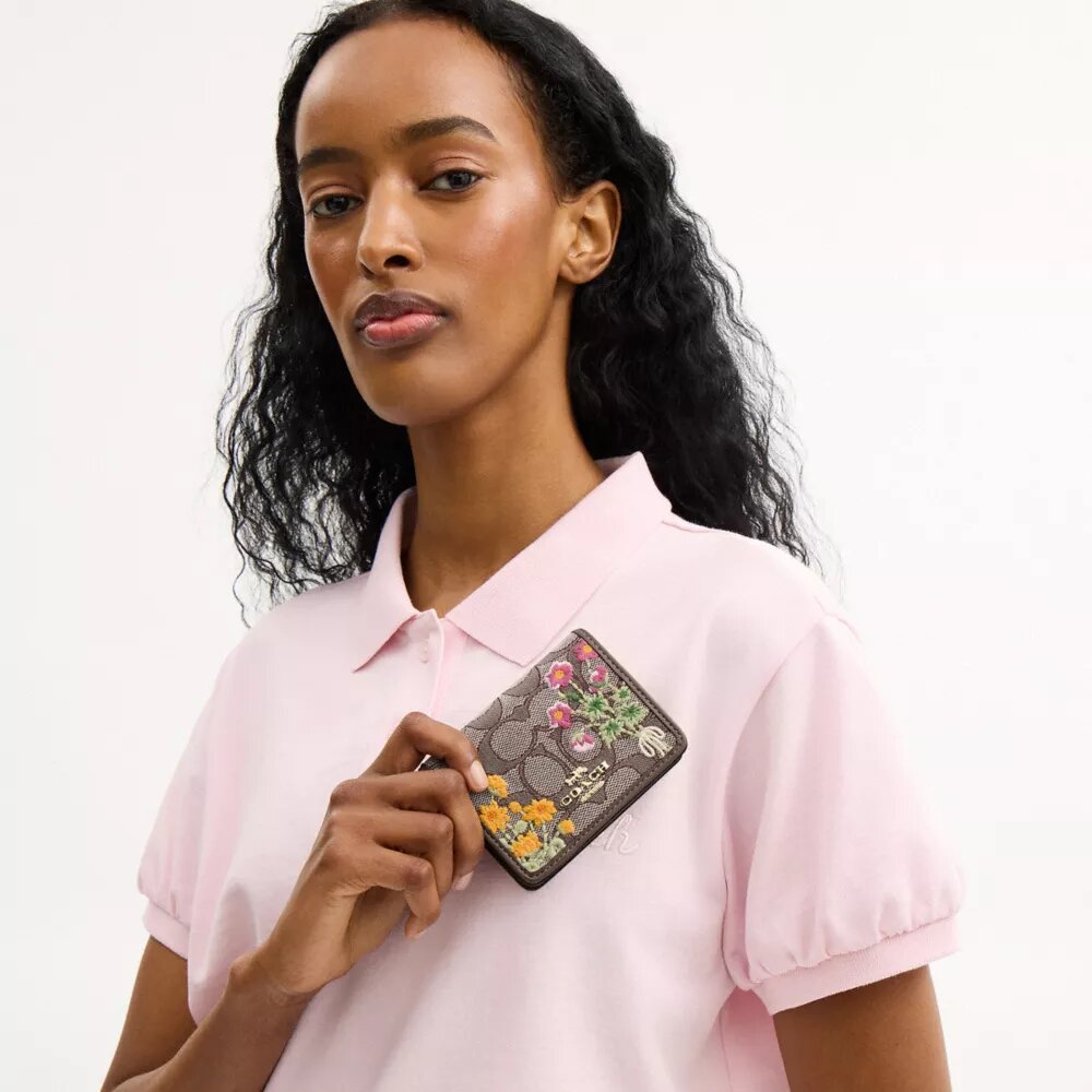 Miniportemonnee aan een ketting van kenmerkend jacquard met bloemenborduursel